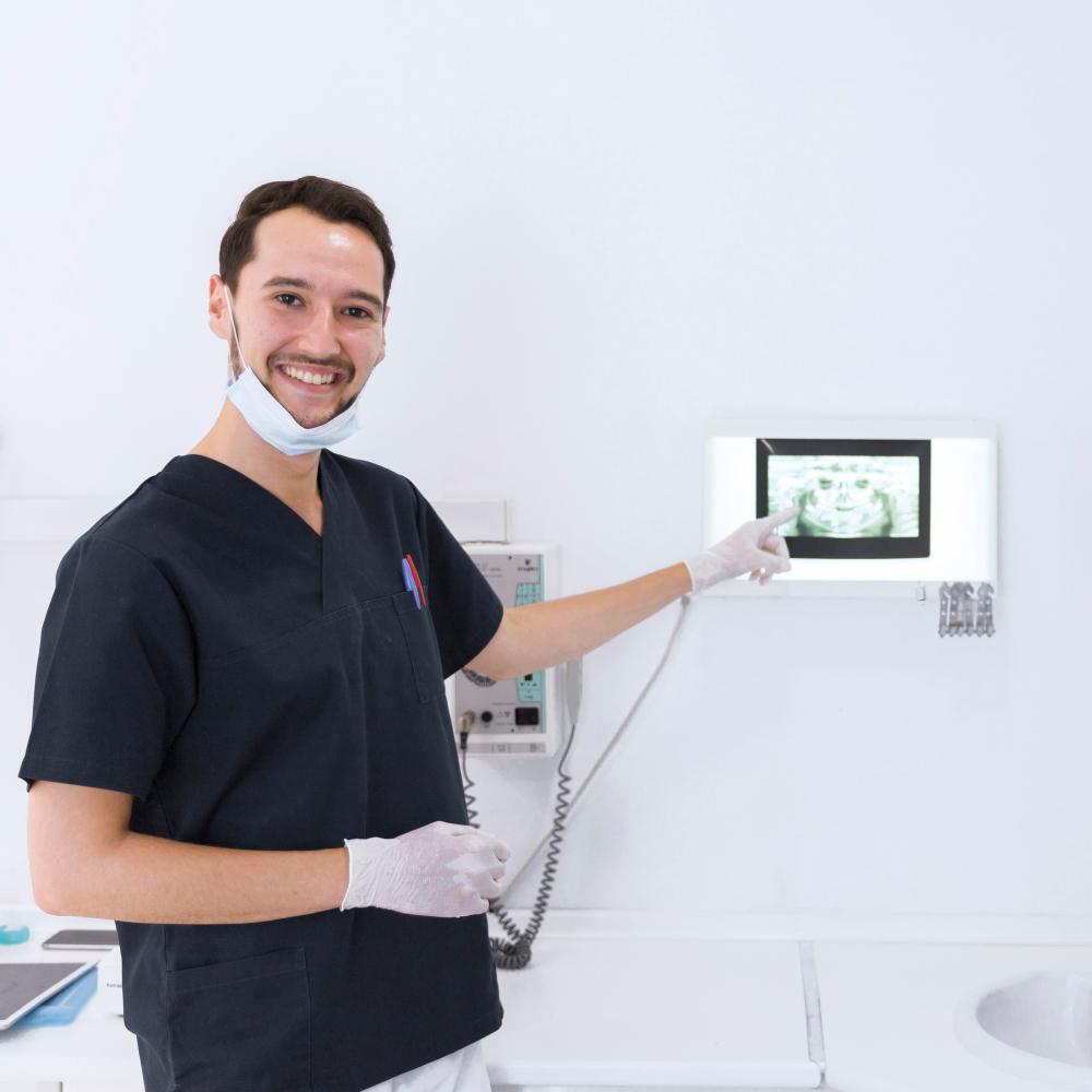 smiling-male-dentist-showing-dental-x-ray
